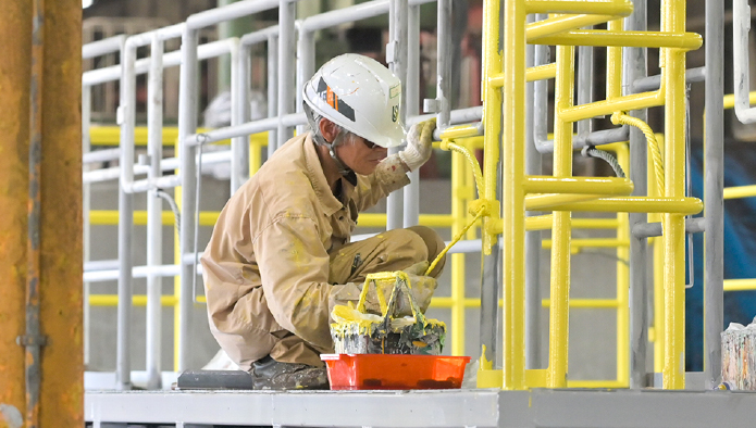 自社工場で金属製品の塗装を行う作業の様子