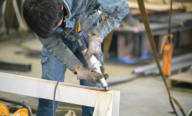 製缶部N.Rさんが鉄骨の研磨作業を行う様子